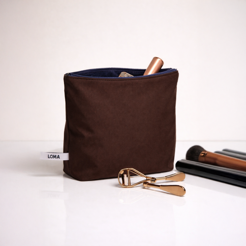 Chocolate brown toiletry bag with makeup and skincare front view