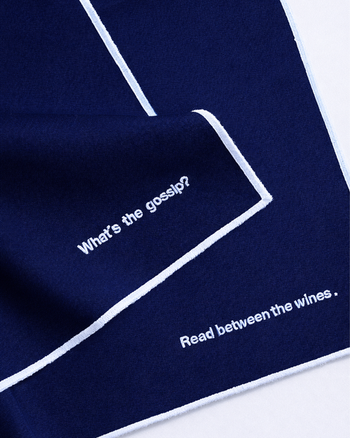 Close up of two navy blue napkins with embroidered white quotes front view