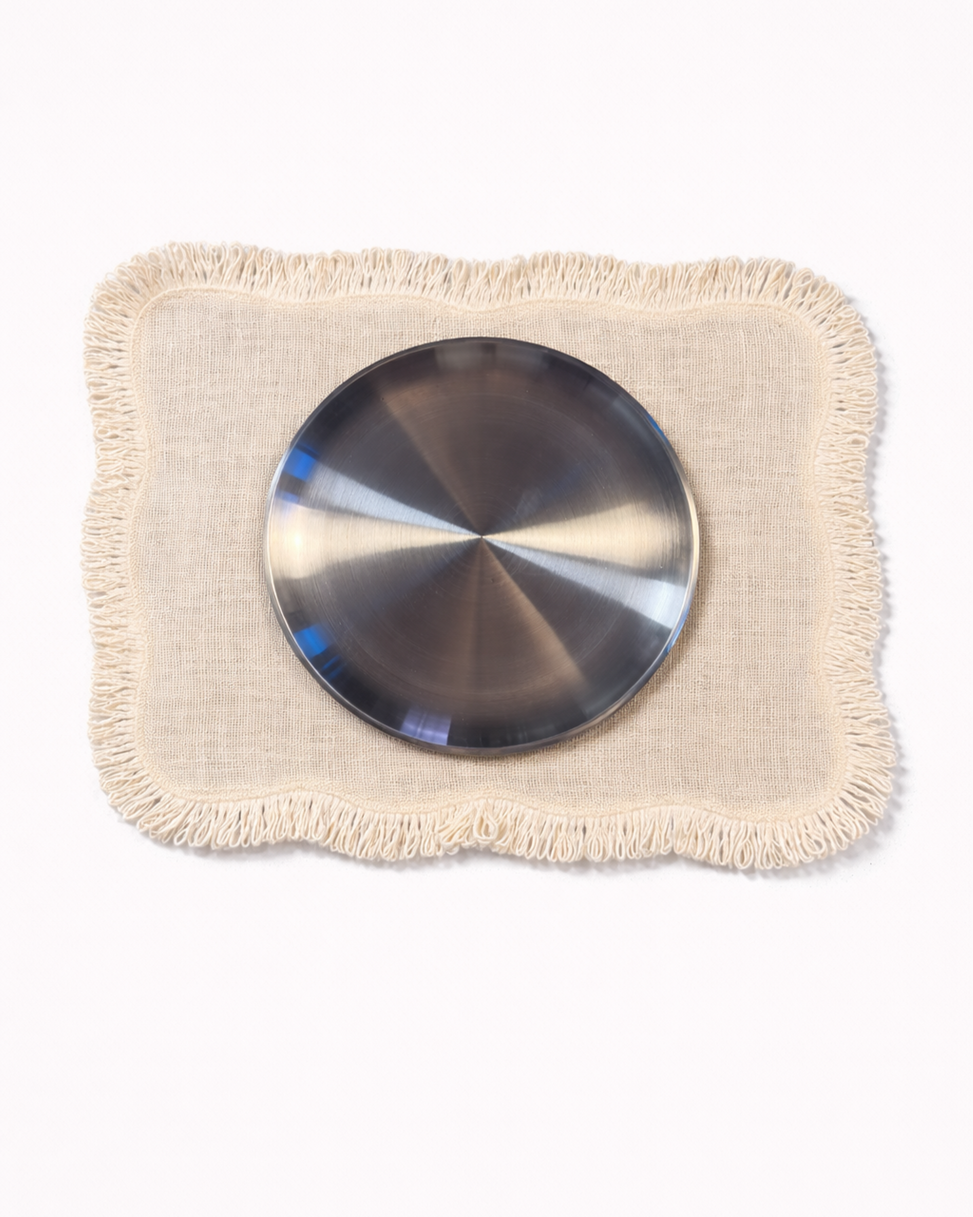 Light jute placemat with fringed edges with chrome tableware front view