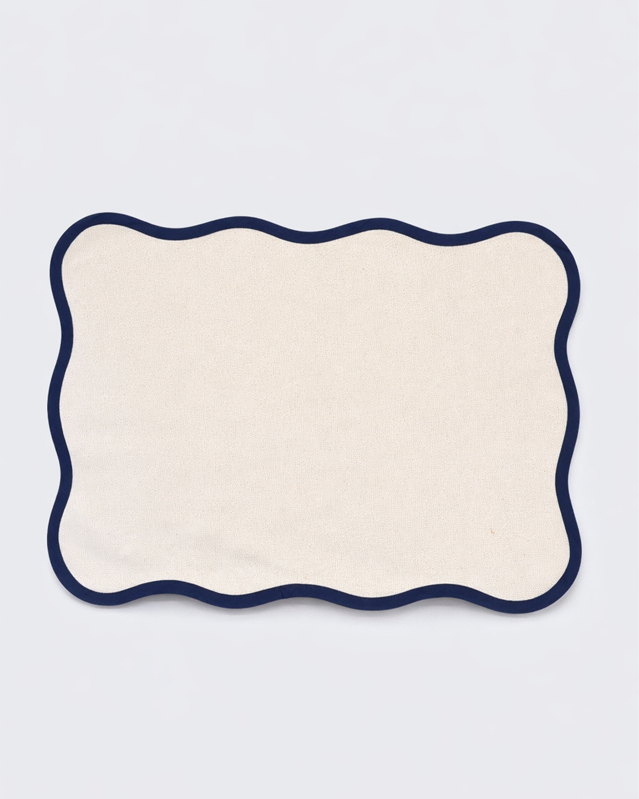 Off-white cotton placemat with scalloped edge front view