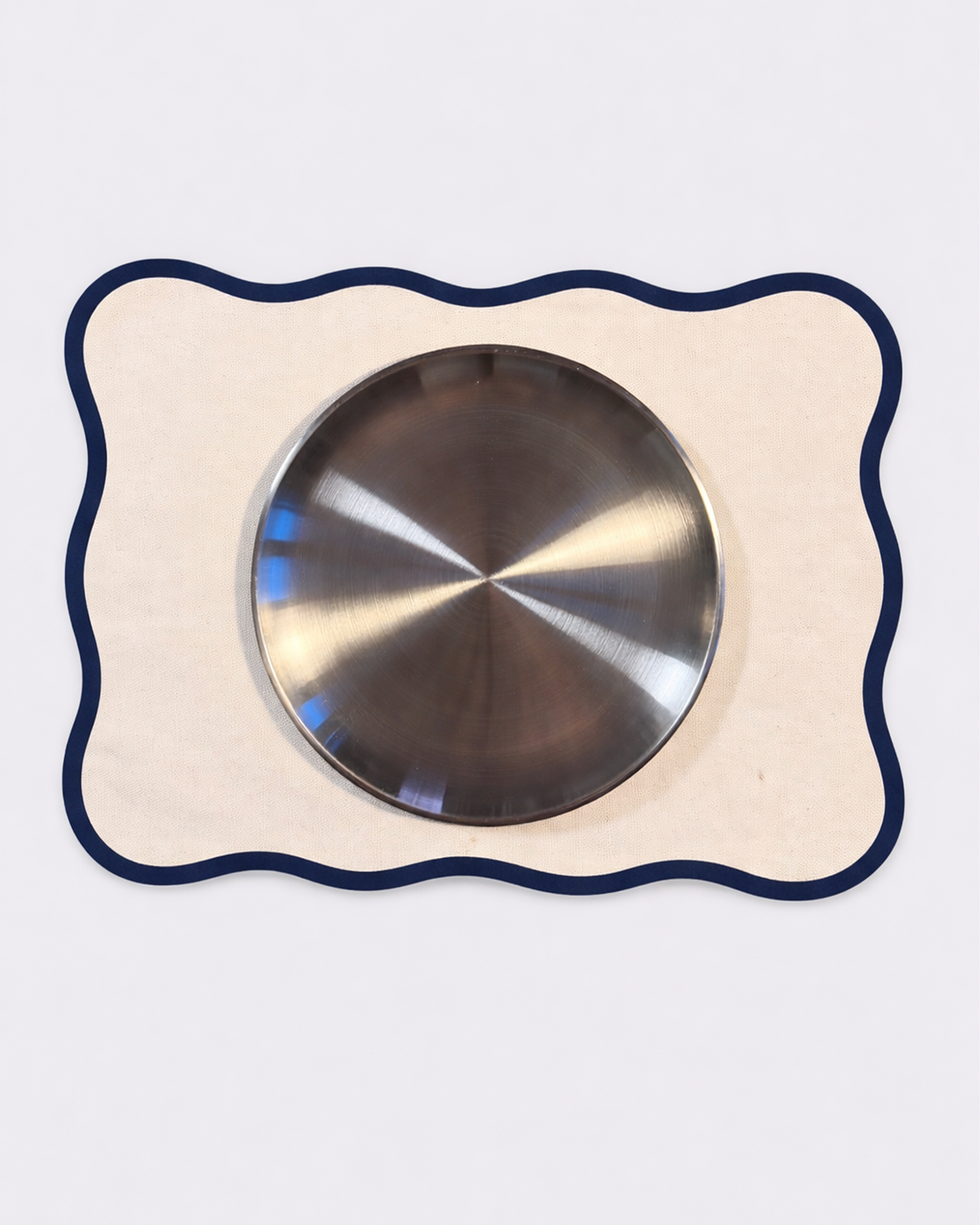 Off-white cotton placemat with chrome tableware front view