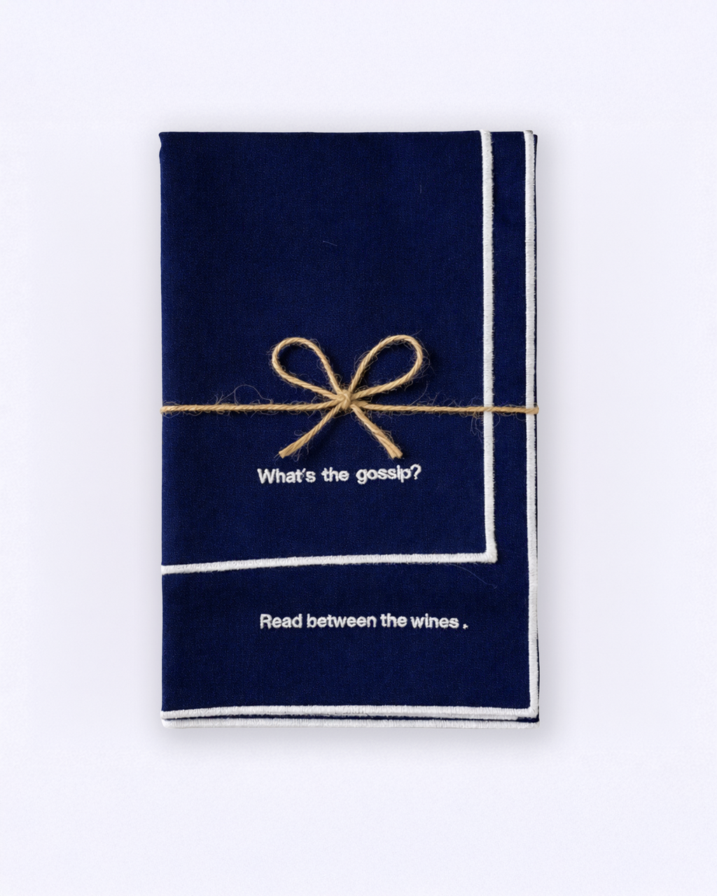 Set of two navy blue napkins with embroidered white quotes wrapped with a bow front view