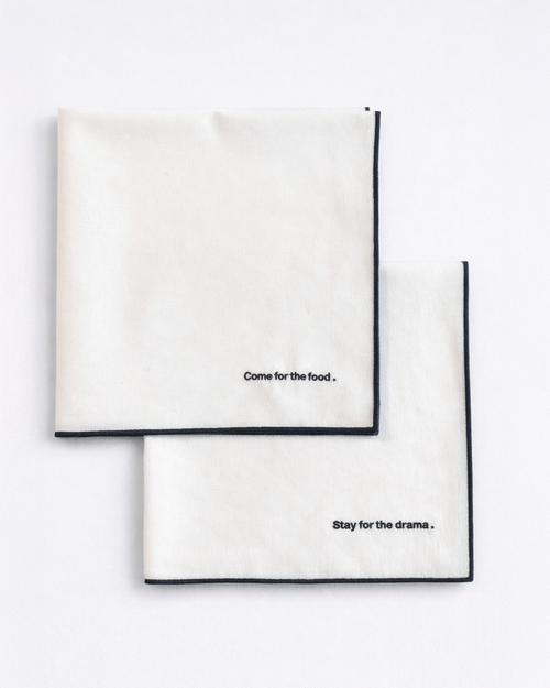 Set of two white napkins with embroidered quotes in navy blue front view